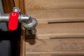 Close-up of a simple, retro faucet for water recruitment with a red handle in a hot sauna, copy space, design element Royalty Free Stock Photo