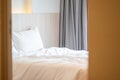 Close up single beds with white bedding are in the cream bedroom of hotel that turn on the headboard light and open the gray Royalty Free Stock Photo