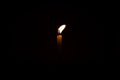 Close Up Single Burning, Bright White Paraffin Candle Light On Isolated Dark Black Background. Red, orange, yellow candle fire Royalty Free Stock Photo