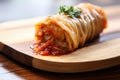 close-up of a single cabbage roll on a bamboo board