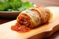 close-up of a single cabbage roll on a bamboo board