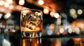 Close up a single glass drink on the rock, whiskey shot with big ice cube, clear brown color alcohol whisky drink, bokeh blurred Royalty Free Stock Photo