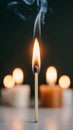 Close-Up of Single Lit Matchstick With Bokeh Candles Against Dark Background Royalty Free Stock Photo