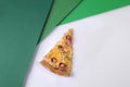 Close-up of Single piece of Italian pizza with hunting sausages, cheese and basil pesto sauce