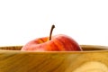 Close up single red Apple above wooden bowl / basket isolated on white background Royalty Free Stock Photo
