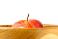 Close up single red Apple above wooden bowl / basket isolated on white background Royalty Free Stock Photo