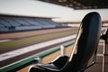 close-up of a single seat, with the view of the race track visible in the background