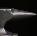 Close up of single steel anvil lying on black background