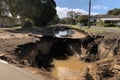 close-up of sinkhole with water and debris flowing into it