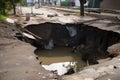 close-up of sinkhole, with water and debris visible