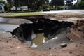 close-up of sinkhole, with water and debris visible