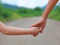 Close up of Sister hold hands with small children walking on the road Royalty Free Stock Photo