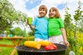 Close-up of sisters grilling corn with paprika