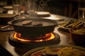 close-up of sizzling hotplate, with plates and silverware in the background