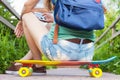 Close-up of skateboarder girl sitting on skateboard outdoor