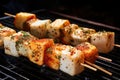 close-up of skewered fish cubes with a dusting of spices