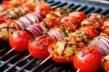 a close-up of skewered grilled tomatoes and onions