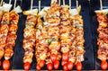 Close up skewers with pieces of grilled barbecue, green bell pepper, red tomato and meat for sell in street market,