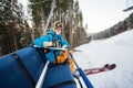 Close-up skier guy with ski sitting at ski-chair lift Royalty Free Stock Photo