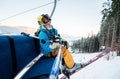 Close-up skier sitting at ski chair lift looking at camera