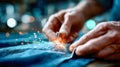 Close-up of skilled hands sewing denim fabric, with tiny sparks flying from the needlework process Royalty Free Stock Photo
