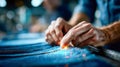 Close-up of skilled hands sewing denim fabric, with tiny sparks flying from the needlework process Royalty Free Stock Photo