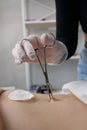 Close up of skin held in piercing tool as needle is ready to go in to pierce naval. Royalty Free Stock Photo