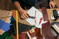 Close up of skinner craftsman working with natural leather using craft tools.