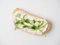 Close-up of a slice of bread spread with cottage cheese and decorated with micro greenery isolated on a white background. The Royalty Free Stock Photo