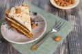 Close-up the slice of carrot cake with almonds on a saucer on wooden table.