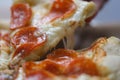 Close-up of a slice pizza with sausage and cheese rises up Royalty Free Stock Photo