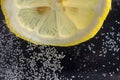 Close-up of slice of lemon in water with defocused bubbles Royalty Free Stock Photo