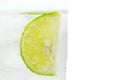 Close up slice of lime in glass sprakling water isolated. Royalty Free Stock Photo