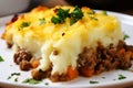 Close-up of a slice of piping hot Shepherd\'s Pie on a white plate with a dollop of sour cream on top