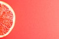 Close up of slice of red grapefruit and copy space on red background Royalty Free Stock Photo