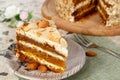 Close-up the slice of vegetarian carrot cake with almonds on a saucer and a fork near.