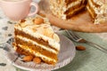 Close-up the slice of vegetarian carrot cake with almonds on a saucer and a fork near