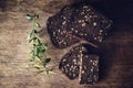 Close-up of the sliced brown bread at the cutting board on the wooden table with black background. Top view Royalty Free Stock Photo