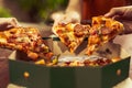 Close up of sliced hot pizza holding by friendship people hands for celebration party. Pizza Margarita cuisine with cheese and Royalty Free Stock Photo