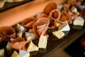 Close-up of sliced pieces of delicious brie cheese and thin slices of prosciutto and salami