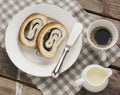 Close up of sliced poppy seed roll on white plate