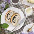 Close up of sliced poppy seed roll on white plate