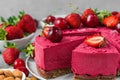 Close up of sliced raw vegan berry cashew cake with fresh strawberry and cherry. Healthy veggie food Royalty Free Stock Photo