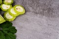 Close-up of sliced and whole bitter melons with leaves on textured surface Royalty Free Stock Photo