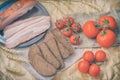 Close-up of slices of bacon, rye black bread, ripe red tomatoes on packaging craft paper. Top view. Fresh organic food Royalty Free Stock Photo