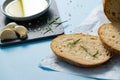 Close up slices of bread with Rosemarie and saucer with olive oil on papyrine on blue background