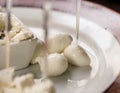 Close-up of slices of mozzarella on a plate with skewers