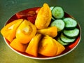 Close-up of slices of yellow and red tomatoes and cucumbers. Vegetables prepared for salad