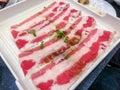 Close up. Slide raw wagyu beef on a red and white plate. uncooked beef, Japanese style for meat grill.