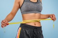 Close up of slim woman measuring her waist`s size with tape measure. Royalty Free Stock Photo